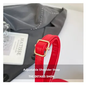 Detail of red leather adjustable shoulder strap with premium golden metal buckle