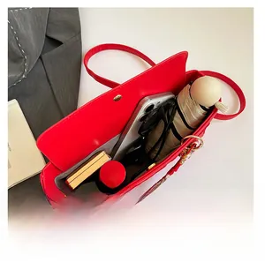 Top view of red handbag interior showing capacity for phone, umbrella, and makeup items