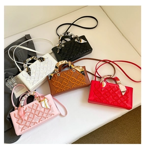 Detail of embroidered quilted handbags with silk scarf handles and fine stitching