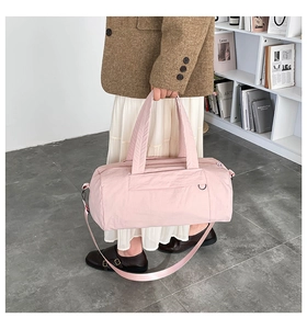 Detailansicht einer rosa Zylindertasche aus Nylon mit verstellbarem Gurt und Gurtbandgriffen
