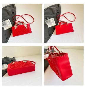 Detail showing red rectangular handbag with embossed leaf patterns and silk scarf handle
