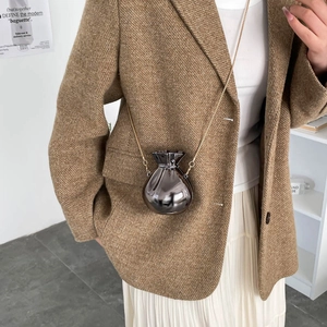 Glossy titanium grey money bag mini crossbody with gold chain on model in neutral setting