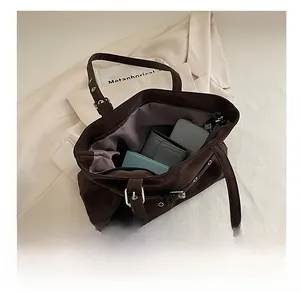 Detailed interior of large dark brown tote bag showing spacious storage with zipper pocket