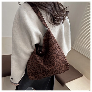 Side view of a large leopard print tote bag styled on model for a chic winter look