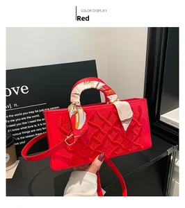 Detail of red quilted leather handbag with decorative floral scarf wrapped around handle