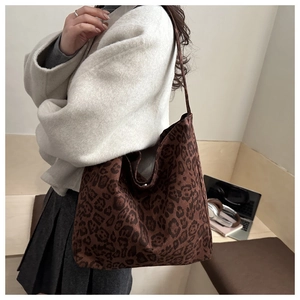 Close-up of leopard print tote bag texture and its drape while worn by a model