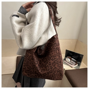 Close-up of leopard print tote bag on shoulder, showcasing fabric texture and large capacity