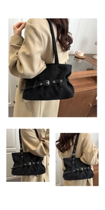 Detail of a matte black tote bag showing metal eyelet belt buckle and elegant pleated texture