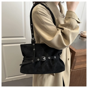 Dettaglio borsa tote in pelle scamosciata nera con fibbia argentata su trench coat