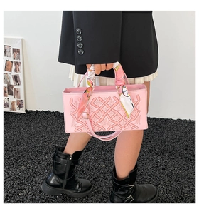 Detailed embroidery on pink crossbody bag featuring silk scarf wrapped top handle