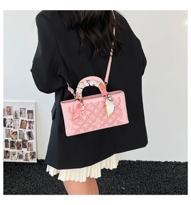Detailed view of pink geometric embossed handbag with a decorative floral silk scarf handle
