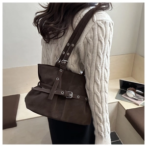 Detail of dark brown vintage leather tote with buckle accents and metallic eyelets
