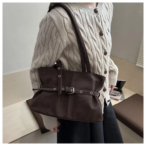 Dettaglio borsa tote in pelle opaca marrone scuro con fibbia decorativa e texture morbida