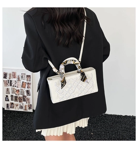Detail of white rectangle handbag with embossed texture and floral silk scarf handle