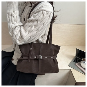 Detail of dark brown faux suede tote bag with silver buckle strap and double shoulder handles