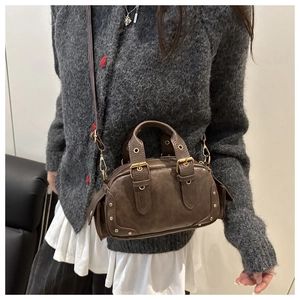 Deep brown faux leather bowling bag with side flap pockets and gold buckle accents