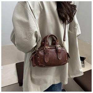 Detail of vintage dark brown handbag with gold studs and textured leather finish
