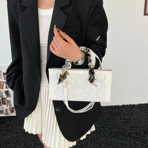 Elegant white embroidered handbag with scarf-wrapped handle and leather shoulder strap