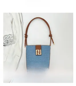 Detailed close-up of blue denim and brown leather stitching with golden metal buckle