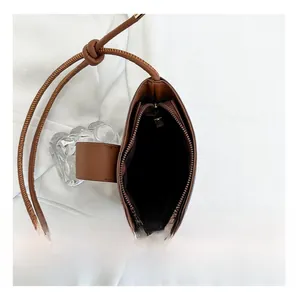 Detail view of the brown leather bucket bag interior with a functional zipper pocket
