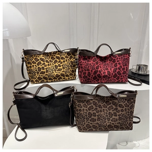 Detail view of leopard print suede tote bags collection in diverse colors on a white display
