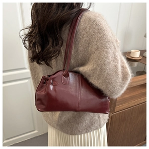 Dettaglio della borsa Boston bordeaux retrò indossata con un outfit invernale chic