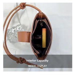 Detail showing internal capacity of the brown bucket bag with lipstick and perfume