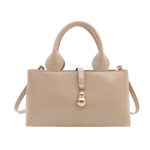 Elegant beige glossy patent leather handbag with gold hardware and top handle for women