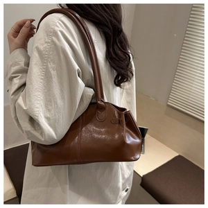 Modello con borsa sottobraccio in pelle lucida marrone scuro con dettaglio coulisse