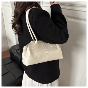 Vista modella di una borsa a spalla in ecopelle crema plissettata con doppie spalline