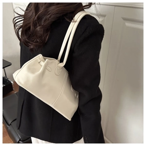 Dettaglio laterale di una borsa a tracolla beige minimalista perfetta per il pendolarismo