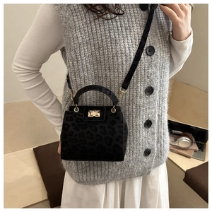 Detail of elegant leopard print crossbody bag with golden metal turn-lock and suede texture