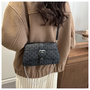 Detail of black monogram shoulder bag with silver chain and metal buckle decoration
