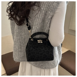 Detail of leopard print handbag featuring gold metal turn-lock and adjustable strap