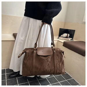 Detail of vintage brown textured leather bag with gold zipper and embossed logo