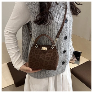 Detail of leopard print small square bag with gold twist lock and crossbody strap
