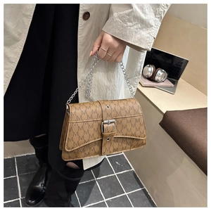 Detail of vintage brown shoulder bag with M-pattern print and silver chain strap