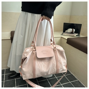 Close-up of pink cloud-textured travel bag with dual handles and brand logo detail