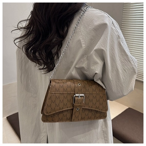Close-up of vintage brown leather bag with M-logo pattern and silver chain strap detail