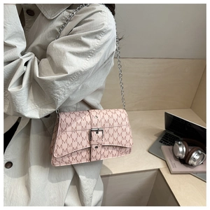 Détail du sac bandoulière rose avec motif M, boucle argentée et bandoulière chaîne