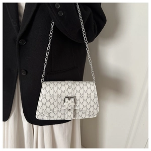 Close-up of beige leather shoulder bag with grey M-letter print and silver chain strap