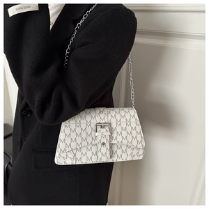 Detail of white crossbody bag with grey M-letter print and silver chain strap on black coat