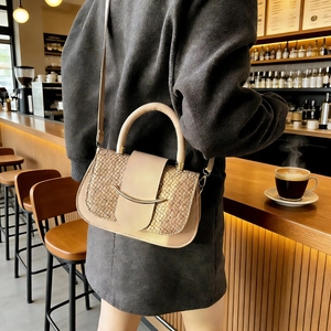 Détail d'un sac besace en cuir tressé beige avec des accents dorés élégants