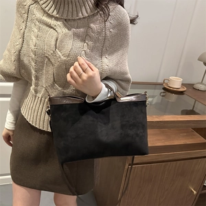 Suede black tote bag with brown leather trim and dual handles for shoulder or hand carry