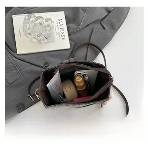 Detailed view of dark brown woven bucket bag interior showing large capacity and zipper pocket