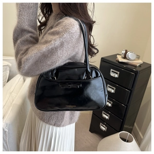 Detail of black faux leather tote with bow decoration and gold logo lettering