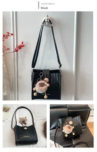 Detail view of black woven bucket bag with adjustable strap and cute sheep charm
