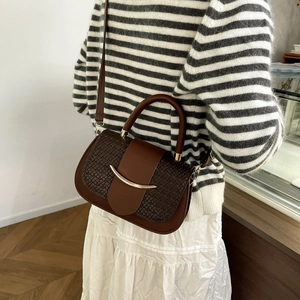 Détail du sac bandoulière en cuir marron foncé avec motif crocodile et boucle dorée