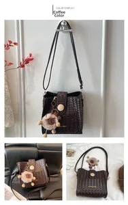 Detailed coffee brown woven texture bucket bag with plush bear charm and magnetic closure