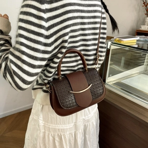 Détail du sac à bandoulière marron foncé avec texture croco et boucle en croissant d'or